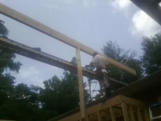 Carpenter setting a ridge beam over a new addition frame — Ice Dam Removal by Roofing Brothers in South Prairie