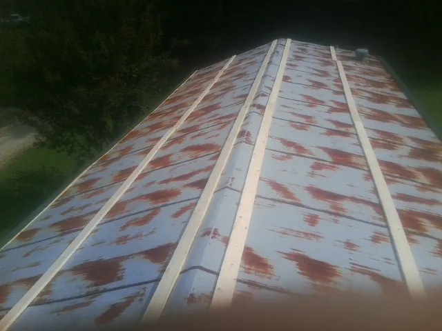 Rusted metal roof panels with new wood purlins before replacement — Storm Damage Roof Repair in South Prairie by Roofing Brothers