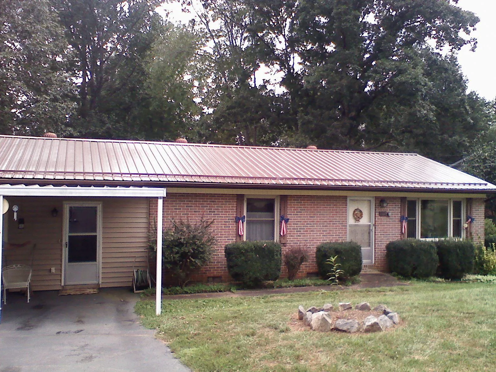 Bronze metal roof and carport on a brick ranch home — Roof Repair work by our crew in South Prairie